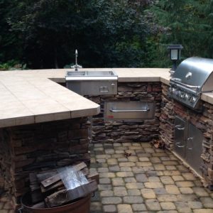 Brick outdoor kitchen with sink, built-in Bull grill and refrigerator in Charlotte, North Carolina