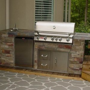 Stone BBQ grill island with refrigerator in Indian Trail, North Carolina