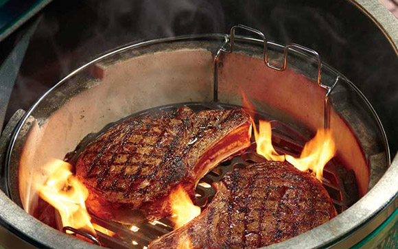 Close up capture of a Big Green Egg Grill cooking two ribeyes