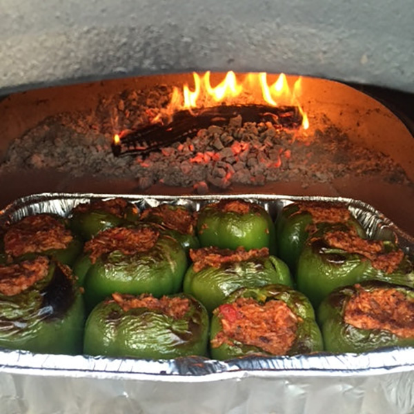 Close up of Stuffed Peppers cooking in a fire brick oven