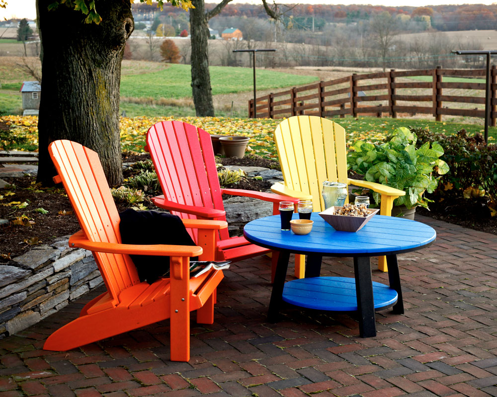 Colorful fanback chairs next to rolling hills and fenced in yard