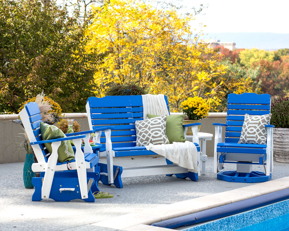 Blue and white outdoor furniture next to paved inground pool