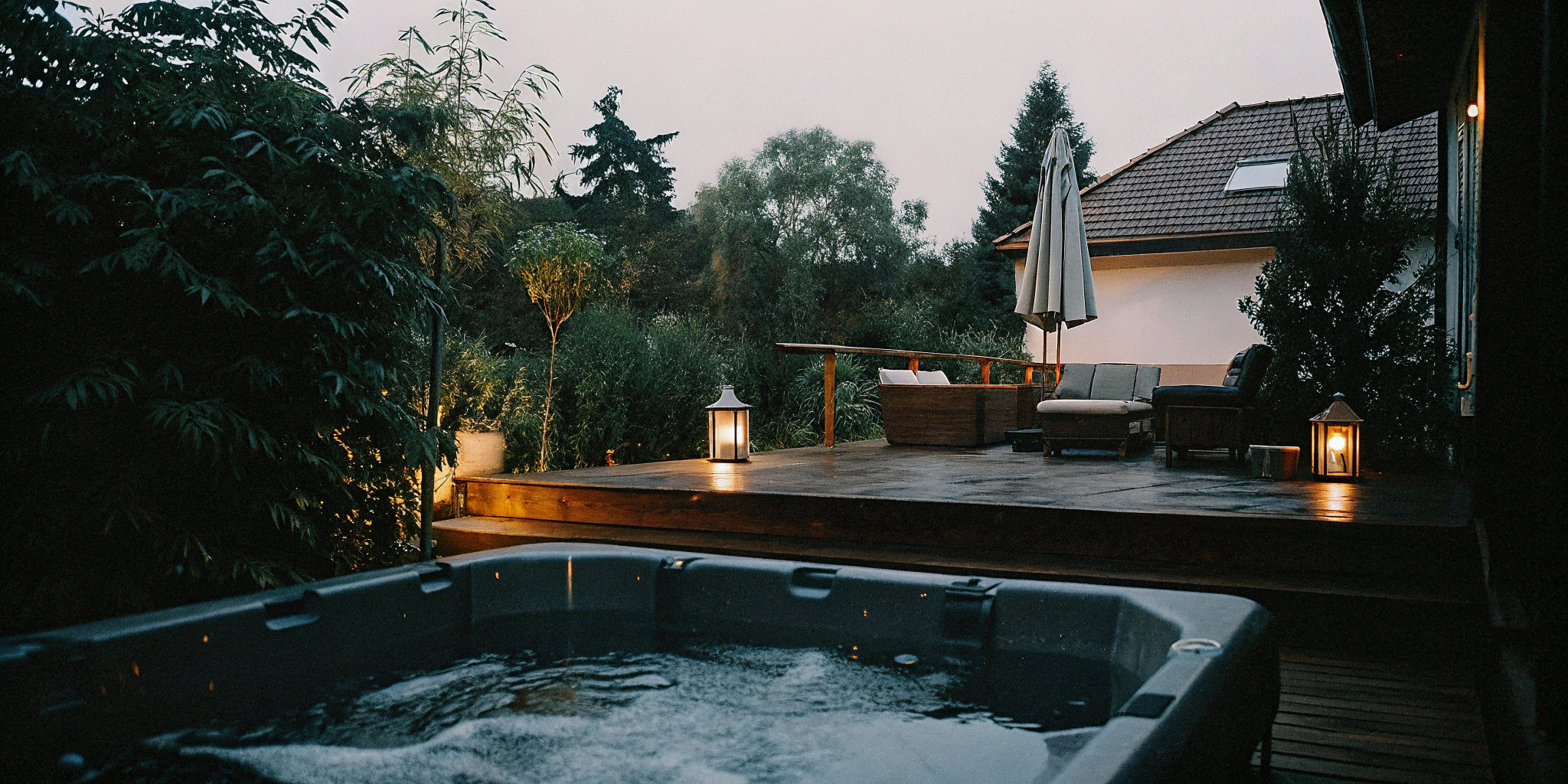 A high-end backyard renovation in Charlotte, NC with a deck and hot tub, a key factor in project cost.