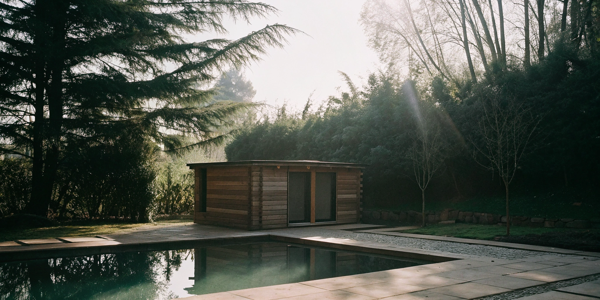 A backyard home sauna next to a pool, a popular outdoor wellness option in Charlotte.