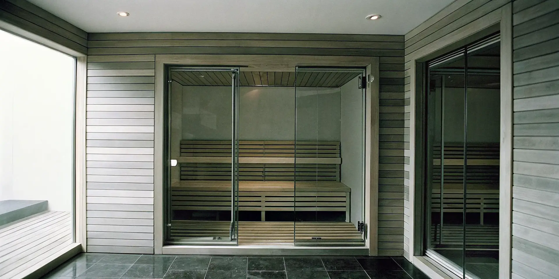 An indoor sauna with a glass door and wood interior in a Charlotte home.