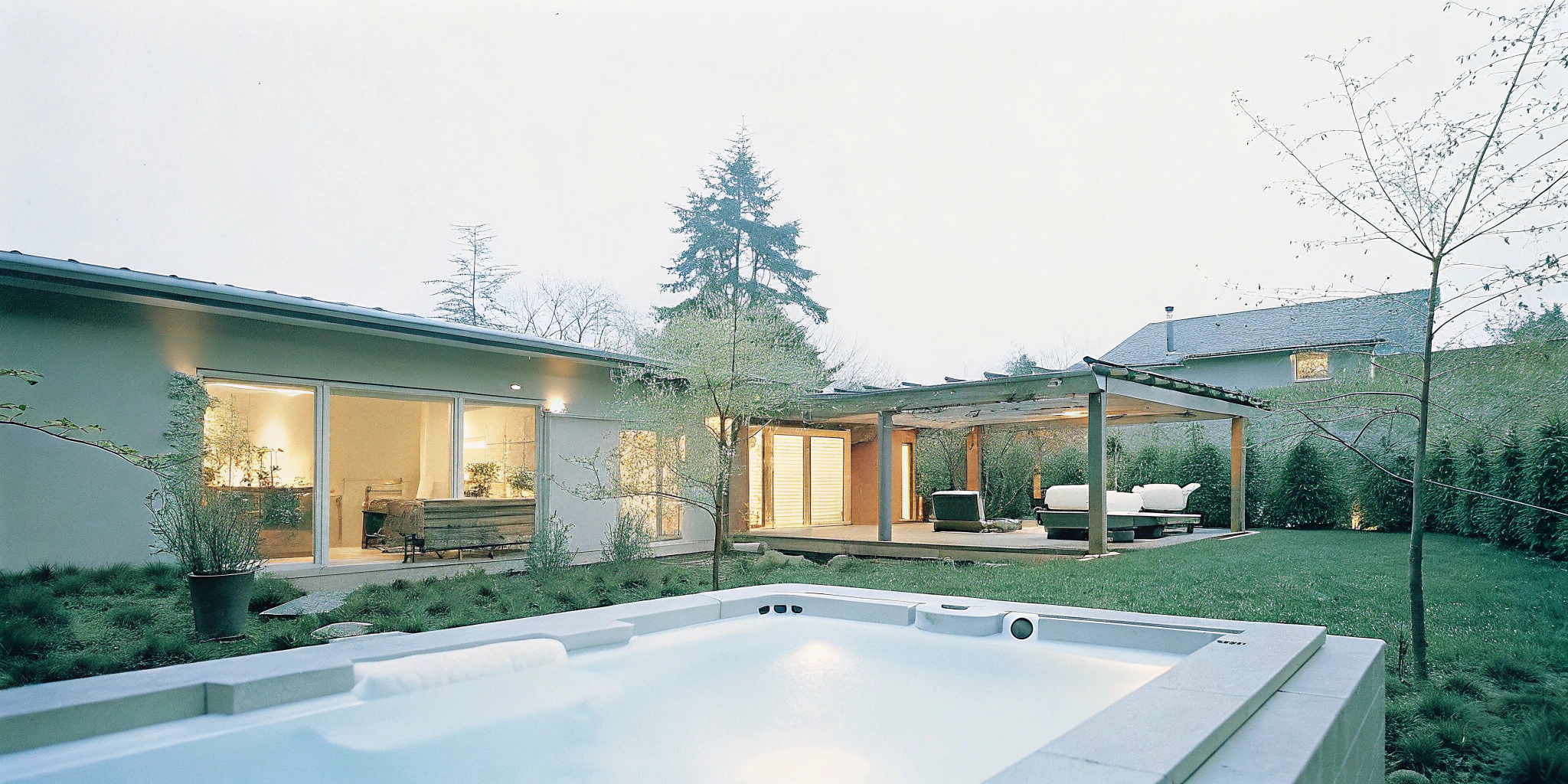 A custom design-build outdoor living space with a modern spa, covered patio, and integrated landscaping.