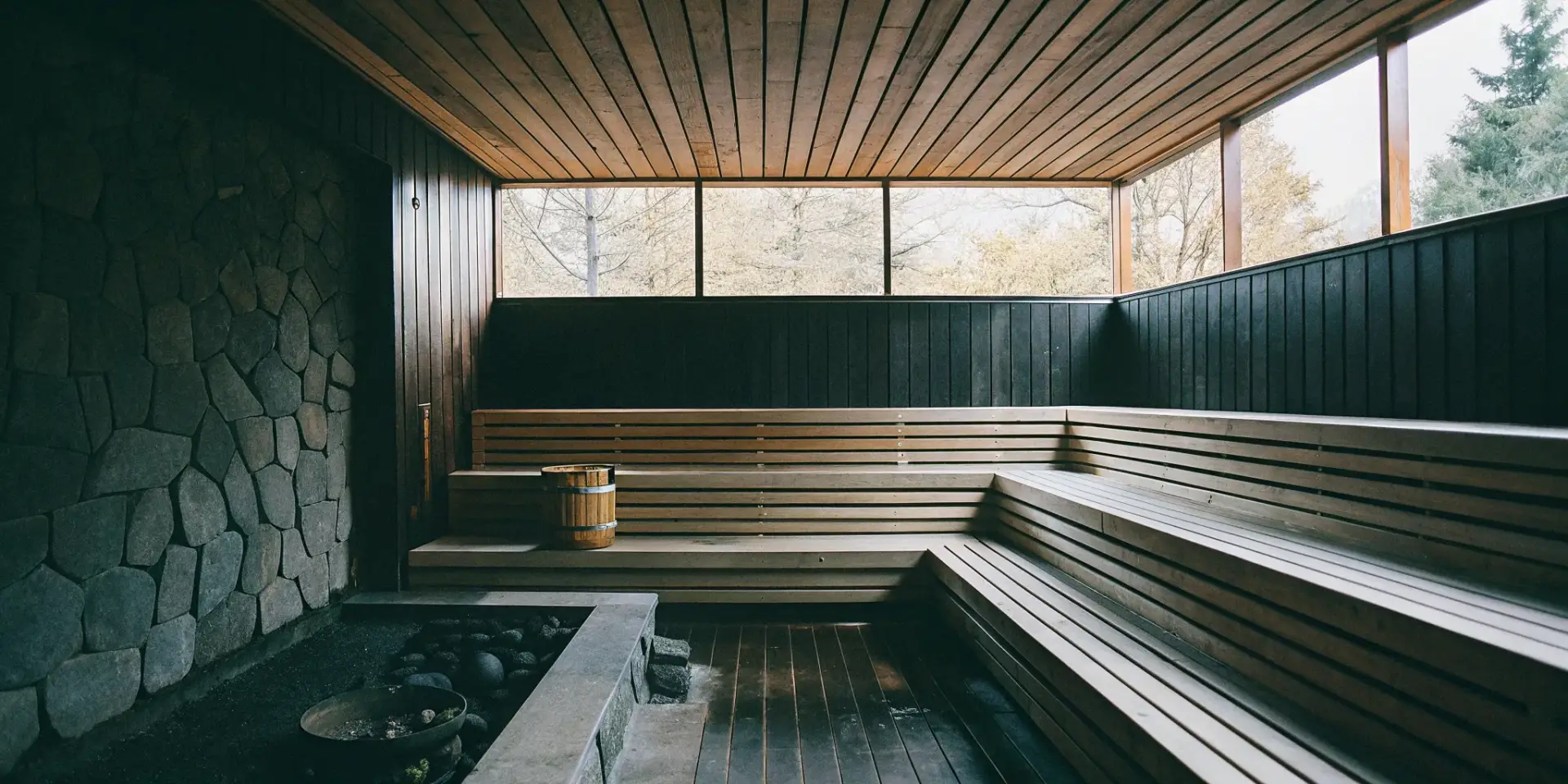 A traditional home sauna with wooden benches and a stone wall in Winston Salem.