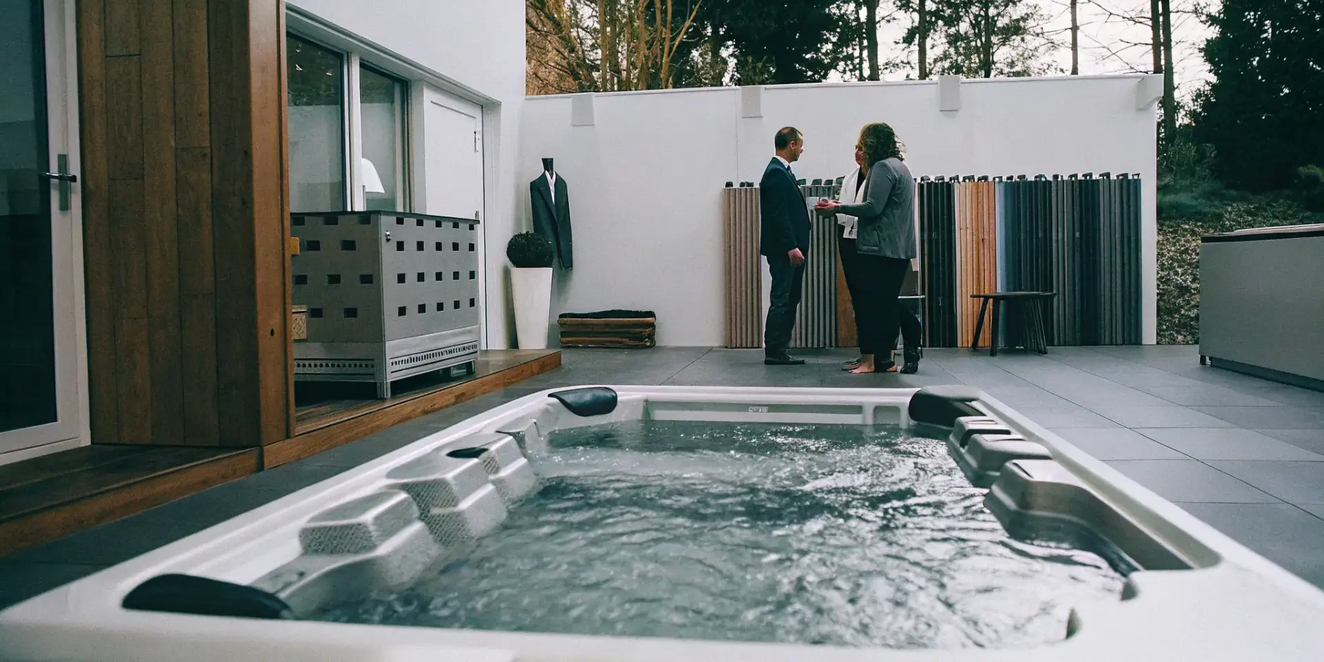 Two people discussing options to buy a swim spa at a showroom in Matthews, NC.