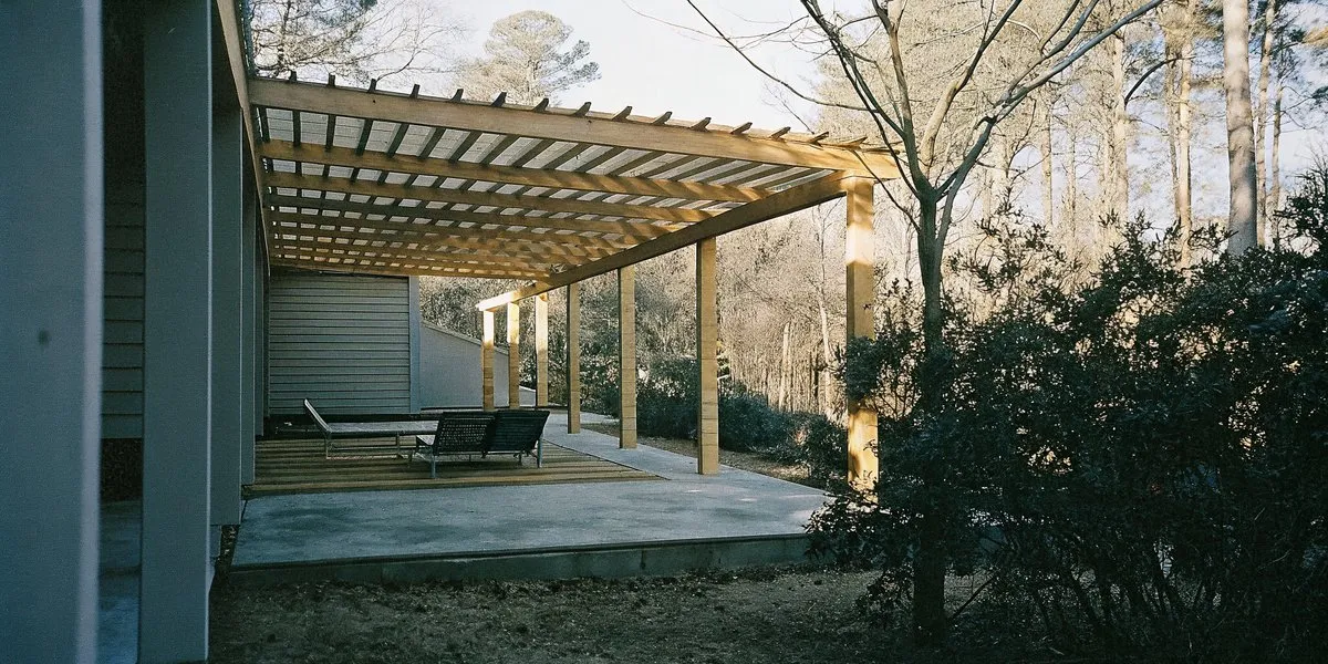 Backyard pergola with comfortable seating and ambient lighting in a Carolina garden setting
